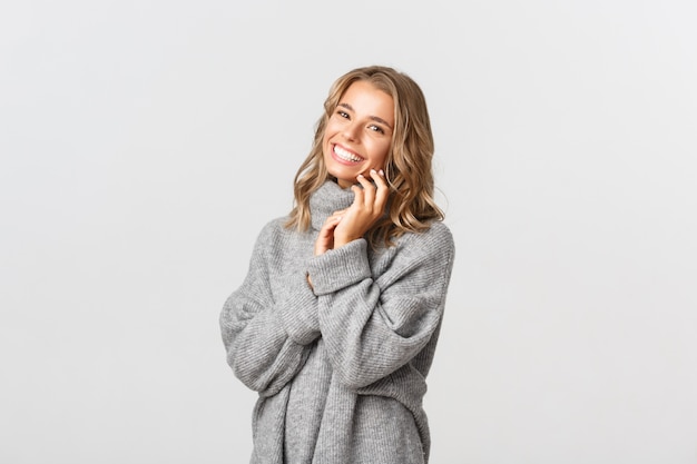 Belle femme dans un pull gris posant