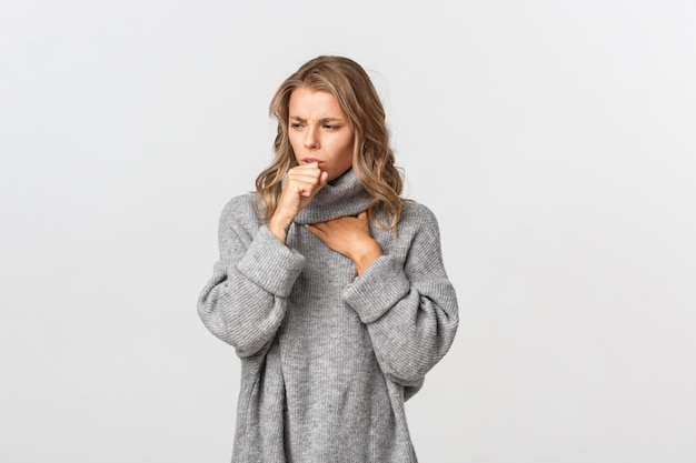 Belle femme dans un pull gris posant