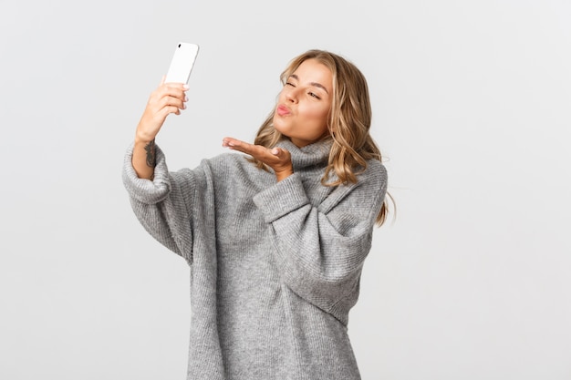 Belle femme dans un pull gris posant