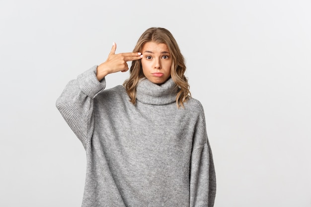 Belle femme dans un pull gris posant