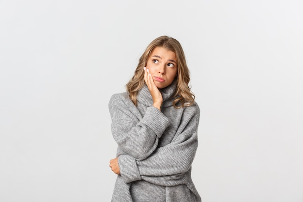 Belle femme dans un pull gris posant