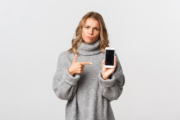 Belle femme dans un pull gris posant