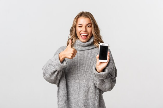 Belle femme dans un pull gris posant