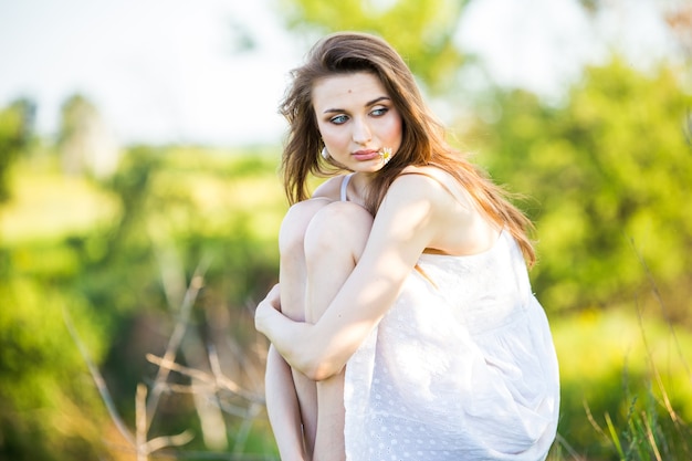 Belle femme dans une robe blanche sur une chaise