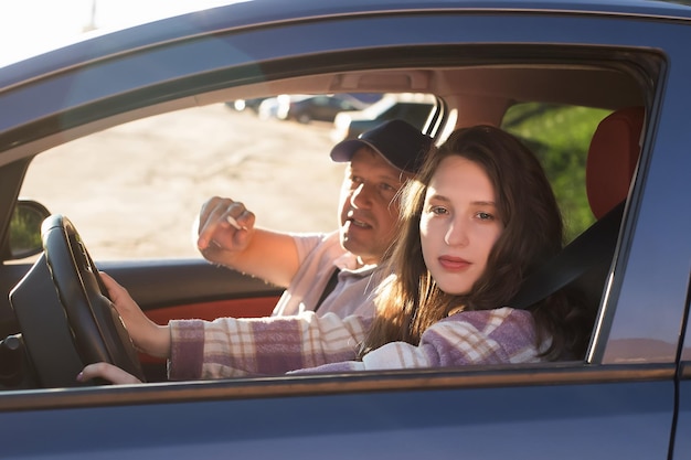 Une belle femme dans une voiture avec un instructeur de conduite Formation et conduite d'une voiture