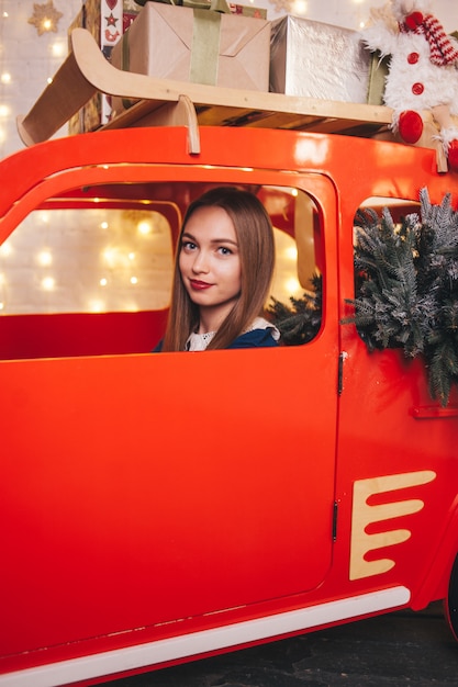 Belle femme dans une voiture à l'intérieur de Noël.