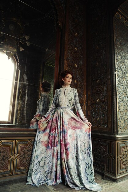 Belle femme debout dans la salle du palais avec miroir