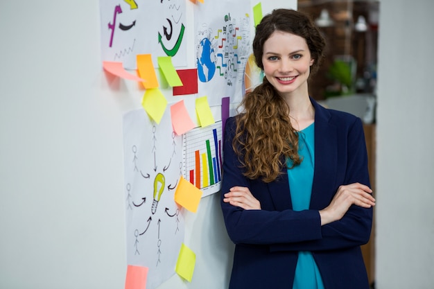 Belle femme debout par mur avec des notes adhésives