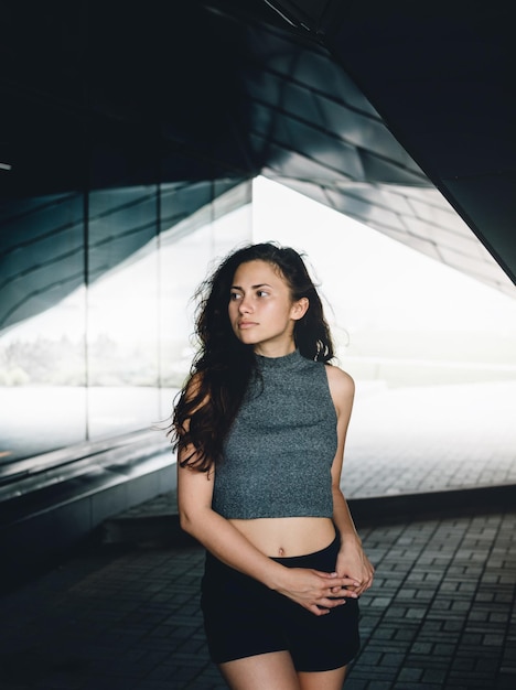 Une belle femme debout sur la passerelle contre le bâtiment