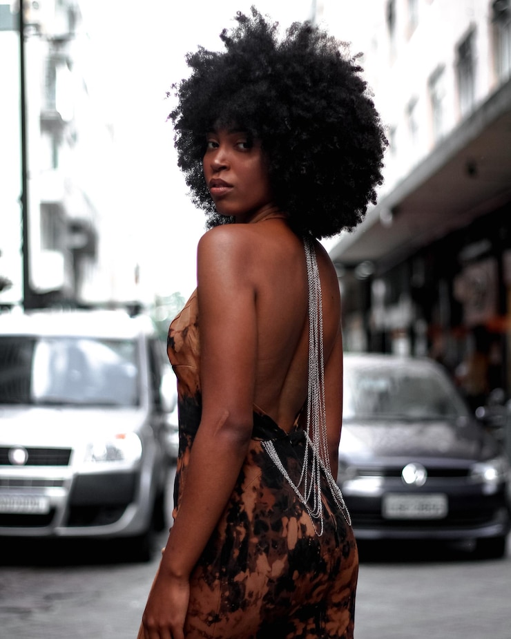 Photo une belle femme debout près de la voiture en ville.