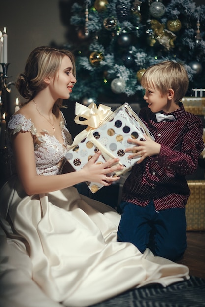 Belle femme donnant un cadeau au petit garçon