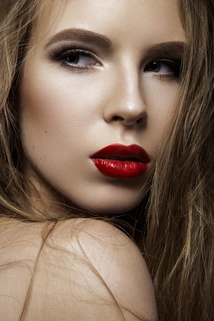 Belle femme avec du maquillage de soirée et de longs cheveux raides