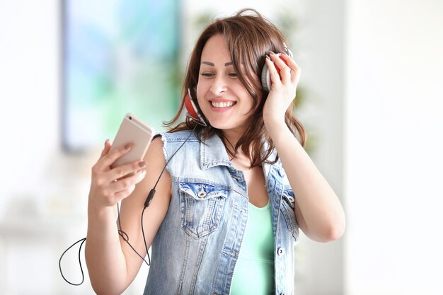 Belle femme écoutant de la musique à la maison