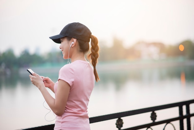 Belle femme écoute de la musique dans le parc