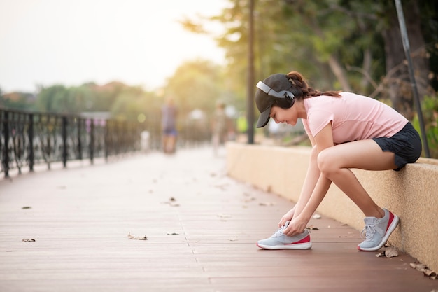 Belle femme écoute de la musique et de l'exercice dans le parc