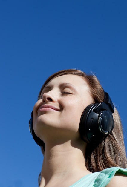 Belle femme écoute de la musique en plein air