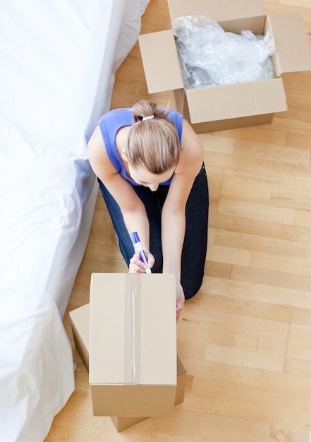 Belle femme écrivant sur une boîte