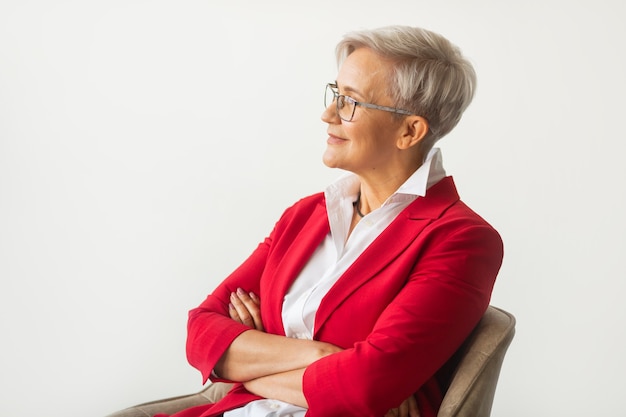 belle femme élégante âgée dans une veste rouge avec des lunettes