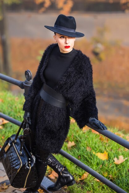 Photo belle femme élégante dans un chapeau noir en automne parc