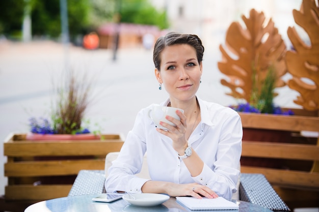 Belle femme élégante avec ordinateur portable, boire du café au café