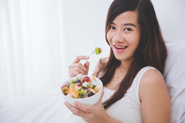 Belle femme enceinte avec un bol de fruits