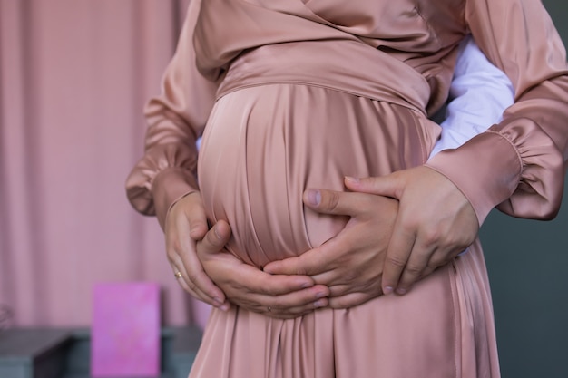 Belle femme enceinte caucasienne en robe rose