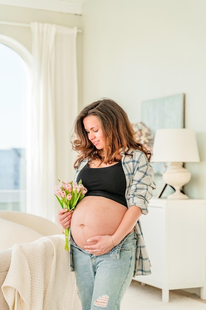 Une belle femme enceinte dans un intérieur moderne et lumineux Bonne grossesse et maternité