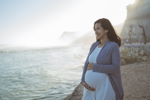 Belle femme enceinte debout sur la plage