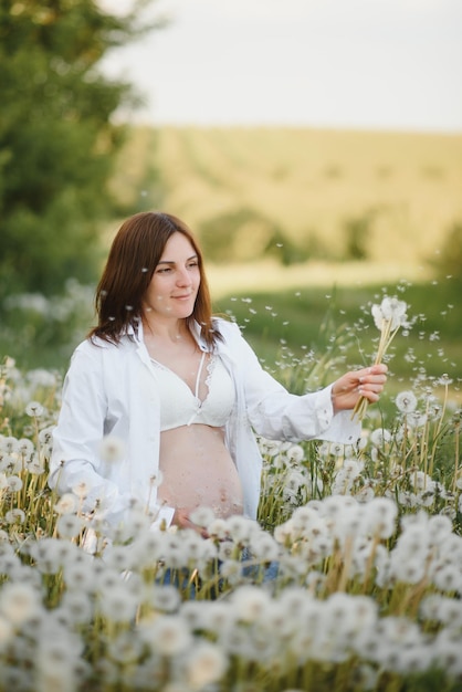 Belle femme enceinte détente dehors dans le parc