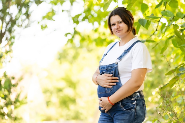 Belle femme enceinte détente dehors dans le parc