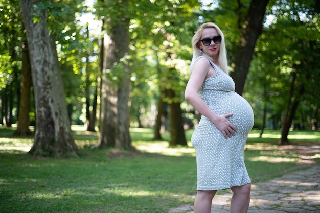 Belle femme enceinte détente dehors dans le parc