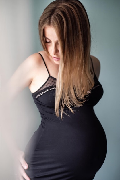 Belle femme enceinte sur fond sombre