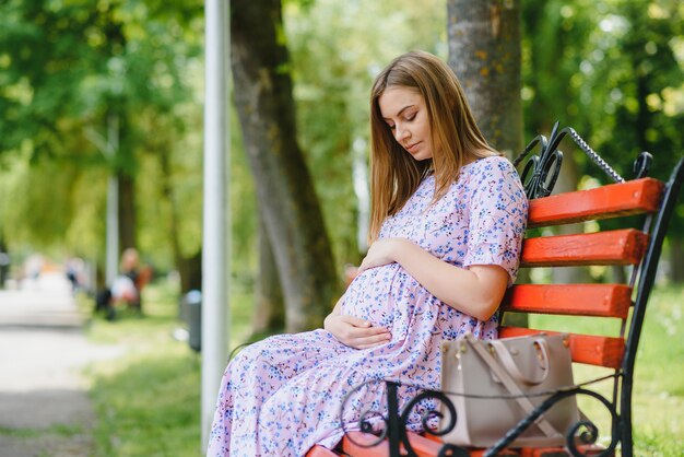 Belle femme enceinte se détendre dans le parc