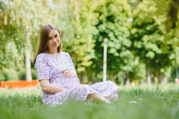 Belle femme enceinte se détendre dans le parc