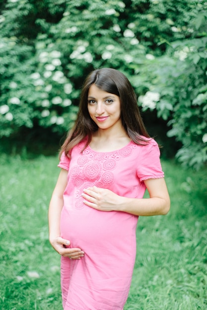 Belle femme enceinte se détendre à l'extérieur dans le parc