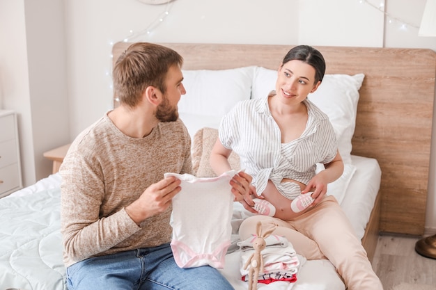 Belle femme enceinte avec son mari à la maison