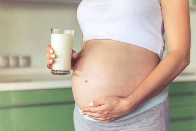 Belle femme enceinte tenant un verre de lait.