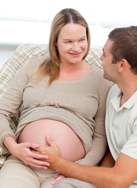 Belle femme enceinte touchant son ventre avec son mari