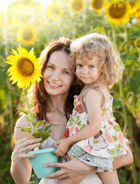 Belle femme et enfant avec tournesol dans le domaine du printemps