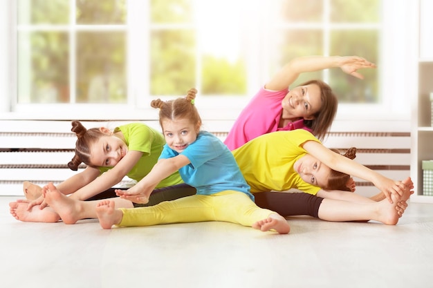 Belle femme avec des enfants faisant des exercices à la maison