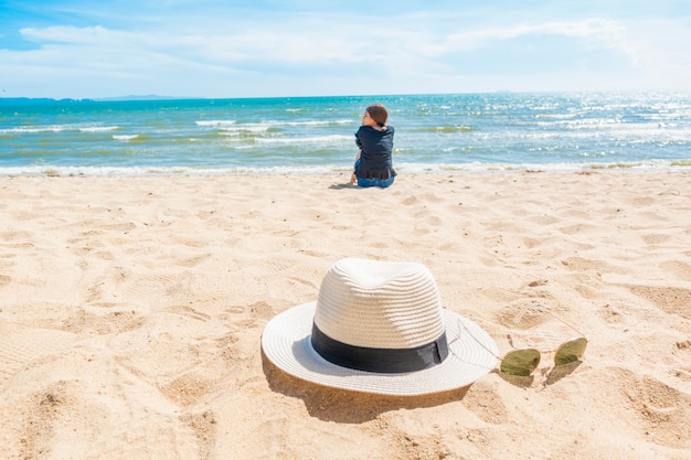 Belle femme est assise sur la plage