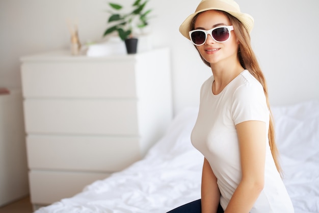 Belle femme est d'emballage des vêtements dans une valise à la maison.