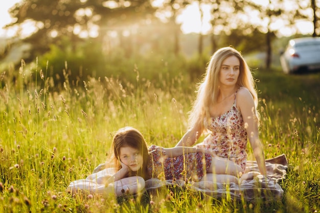 Belle femme étreint son adorable petite fille Heureux parent passe du temps à jouer avec sa fille dans le parc au coucher du soleil Fête des mères bébé Concept de famille mise au point sélective