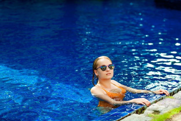 Belle femme expressive posant dans la piscine