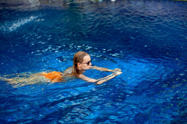 Belle femme expressive posant dans la piscine