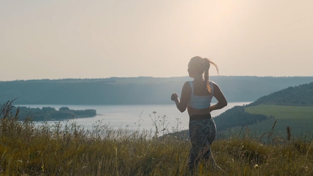 La belle femme faisant du jogging sur le fond pittoresque