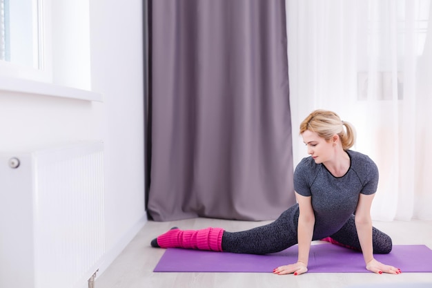 Belle femme faisant du yoga à la maison