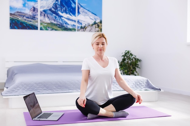 Belle femme faisant du yoga à la maison