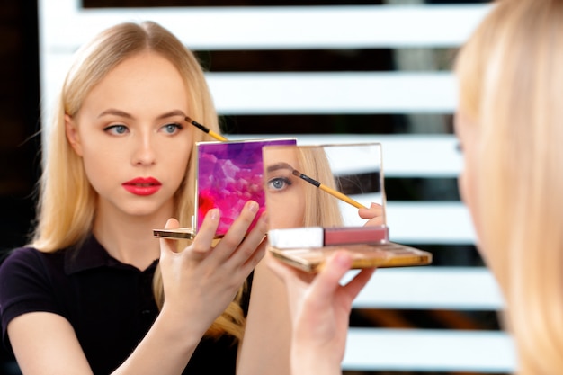 Belle femme faisant le maquillage du soir