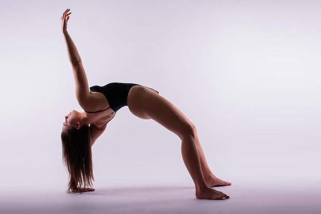 Belle femme faisant des poses sur le tir de studio de cours de yoga